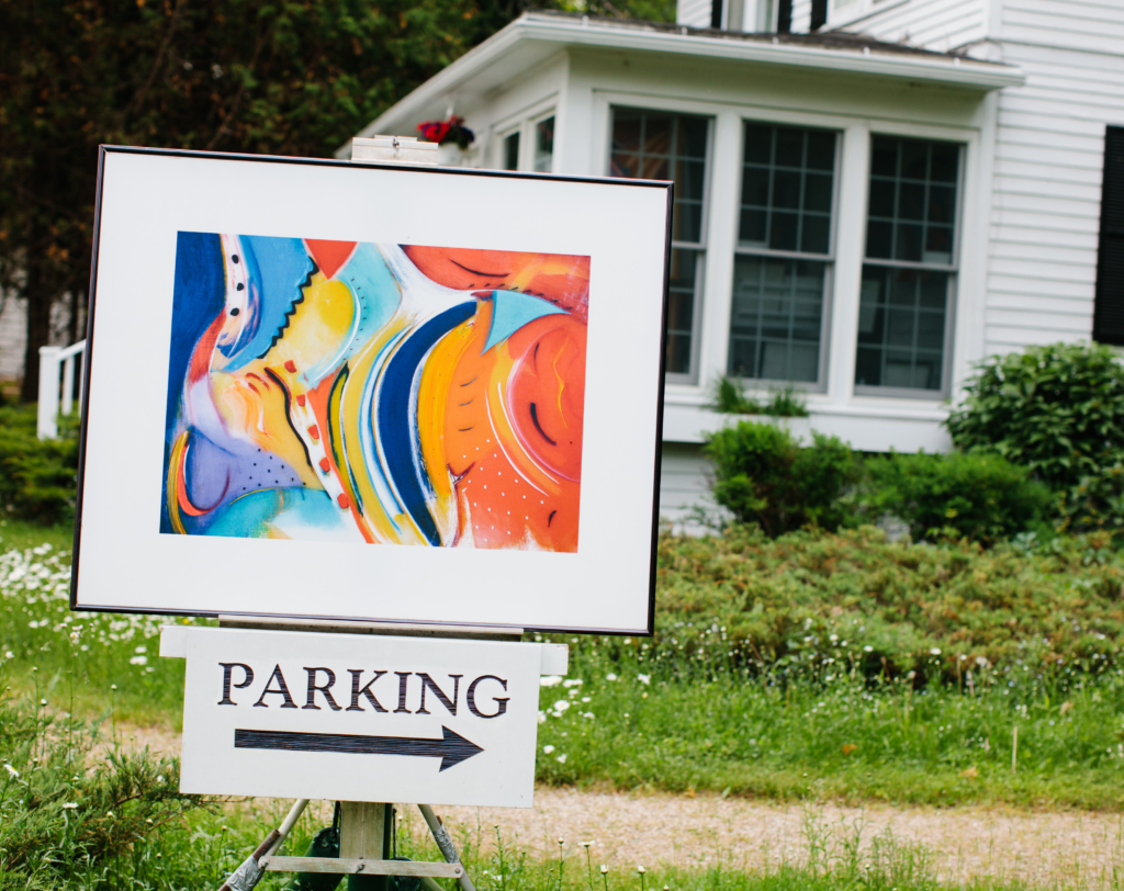 Multi-colored painting on an easel in front of house