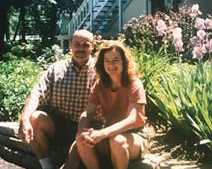 Man and woman sitting in front of flowers