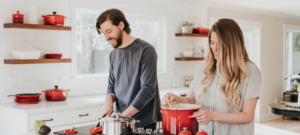 Man and woman cooking Eagle Harbor Inn corn chowder in bright kitchen