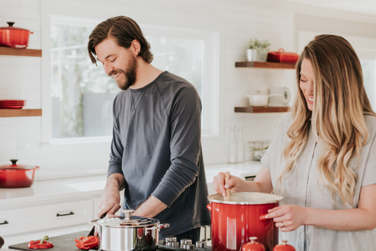 Man and woman cooking Eagle Harbor Inn corn chowder in bright kitchen